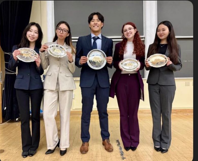 Five finalists in suits holding silver commemorative plates