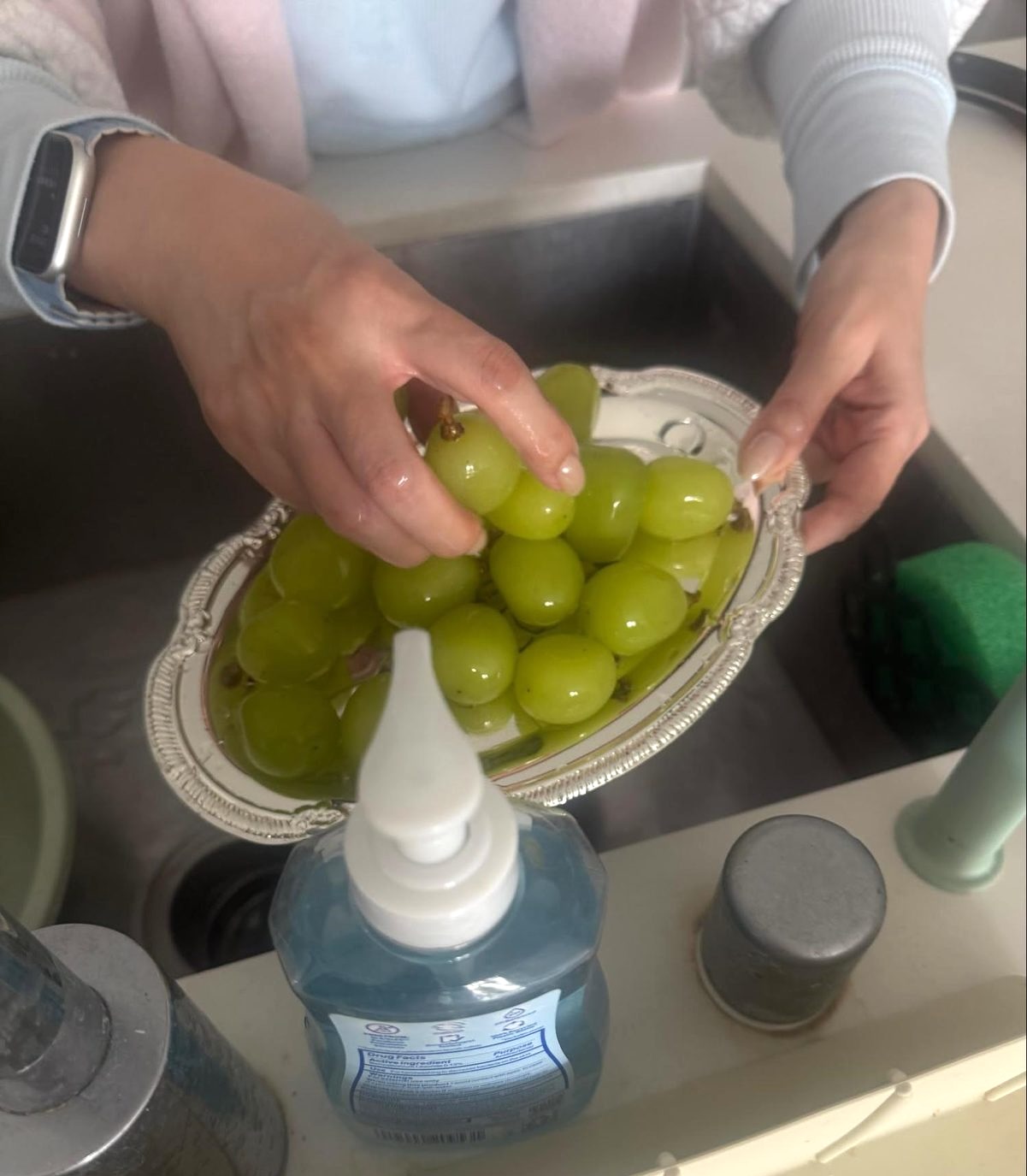 Green grapes being washed in a silver award plate