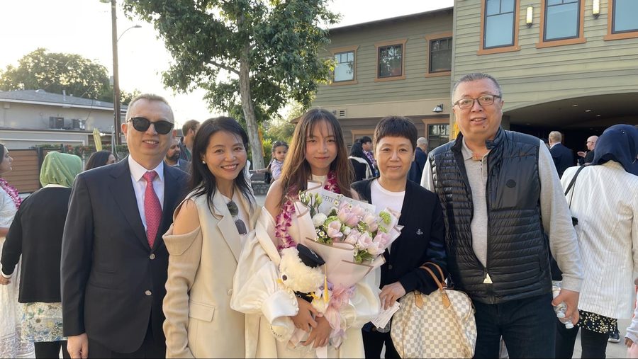 Michelle with her family and a bouquet after her middle school graduation